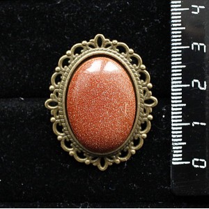 Брошь из авантюрина красного (синт.), овал 25х18мм, оправа с узором цвет бронза