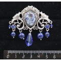Брошь из лазурита бело-синего "трюмо", овал 18х13мм, со стразами и подвесками из хрусталя
