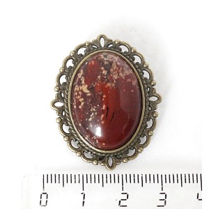 Брошь из яшмы красно-коричневой, овал 25х18мм, оправа с узором цвет бронза